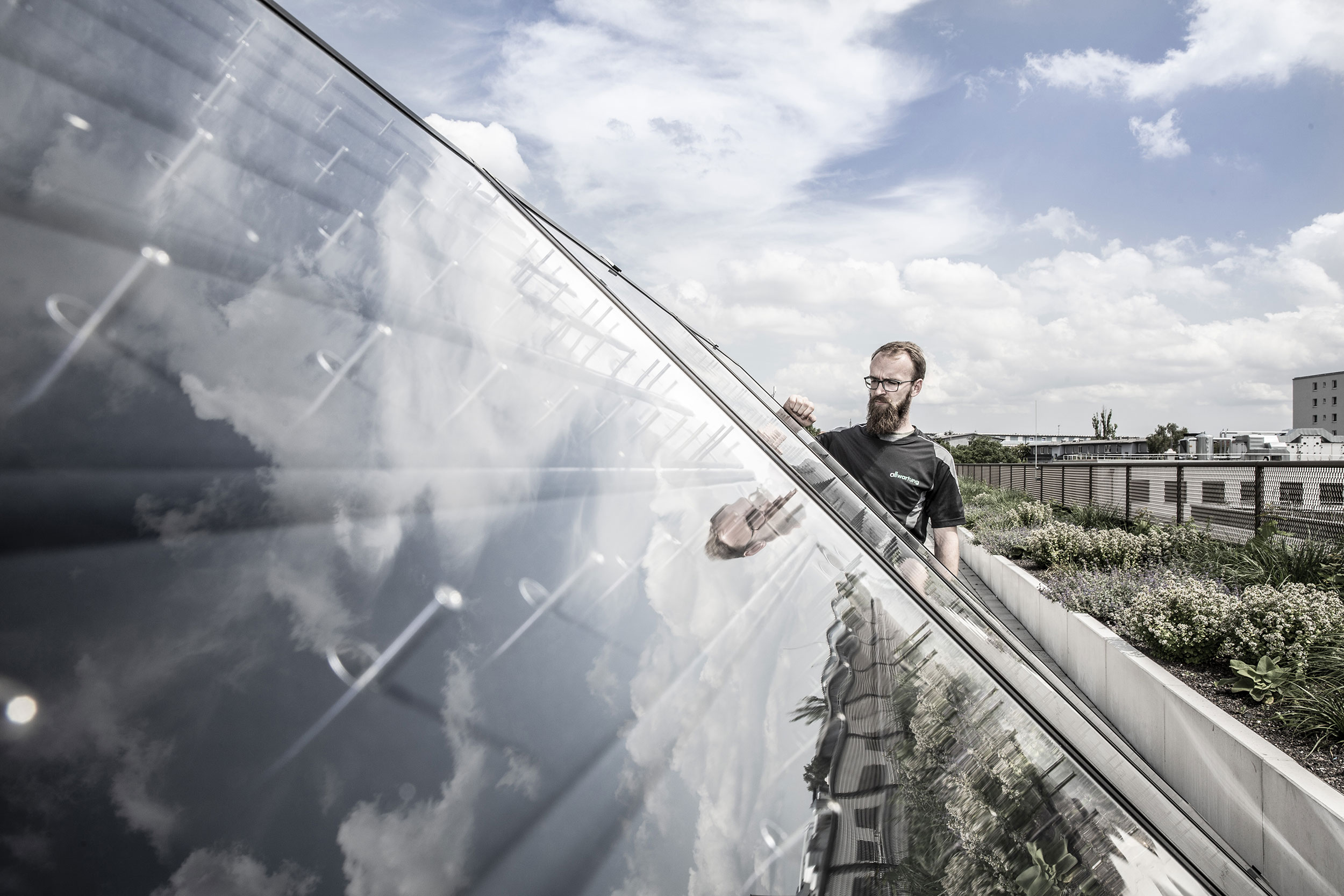 Ein Mann inspiziert eine Photovoltaikanlage in München, die innovative Klimatechnik für nachhaltige Energie nutzt.