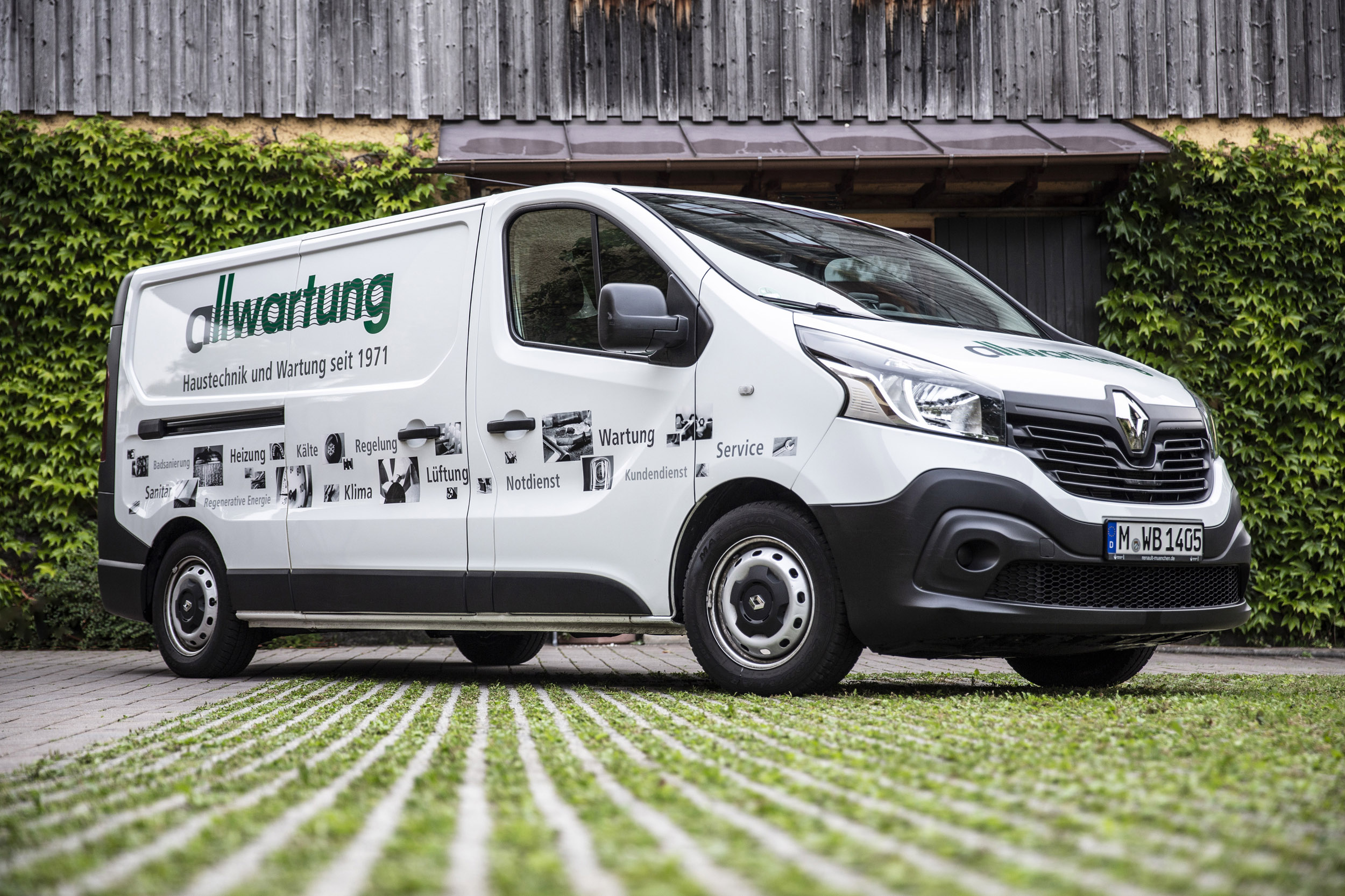 Ein Firmenwagen von Allwartung in München wirbt für Heiztechnik und andere Dienstleistungen vor grüner Kulisse.